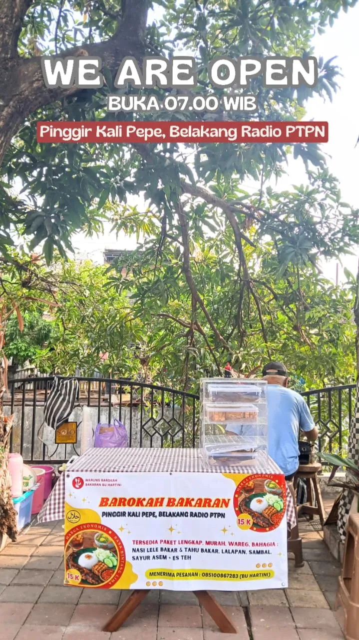 Papan warung bertuliskan sedang buka pukul 07.00 WIB di Pinggir Kali Pepe, belakang Radio PTPN.